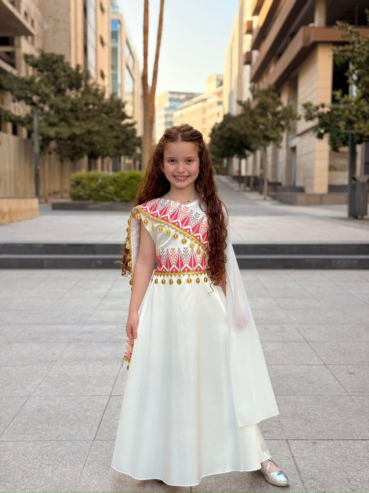 White girls embroidered shoulder dress with red Tatreez-inspired details and gold coin accents