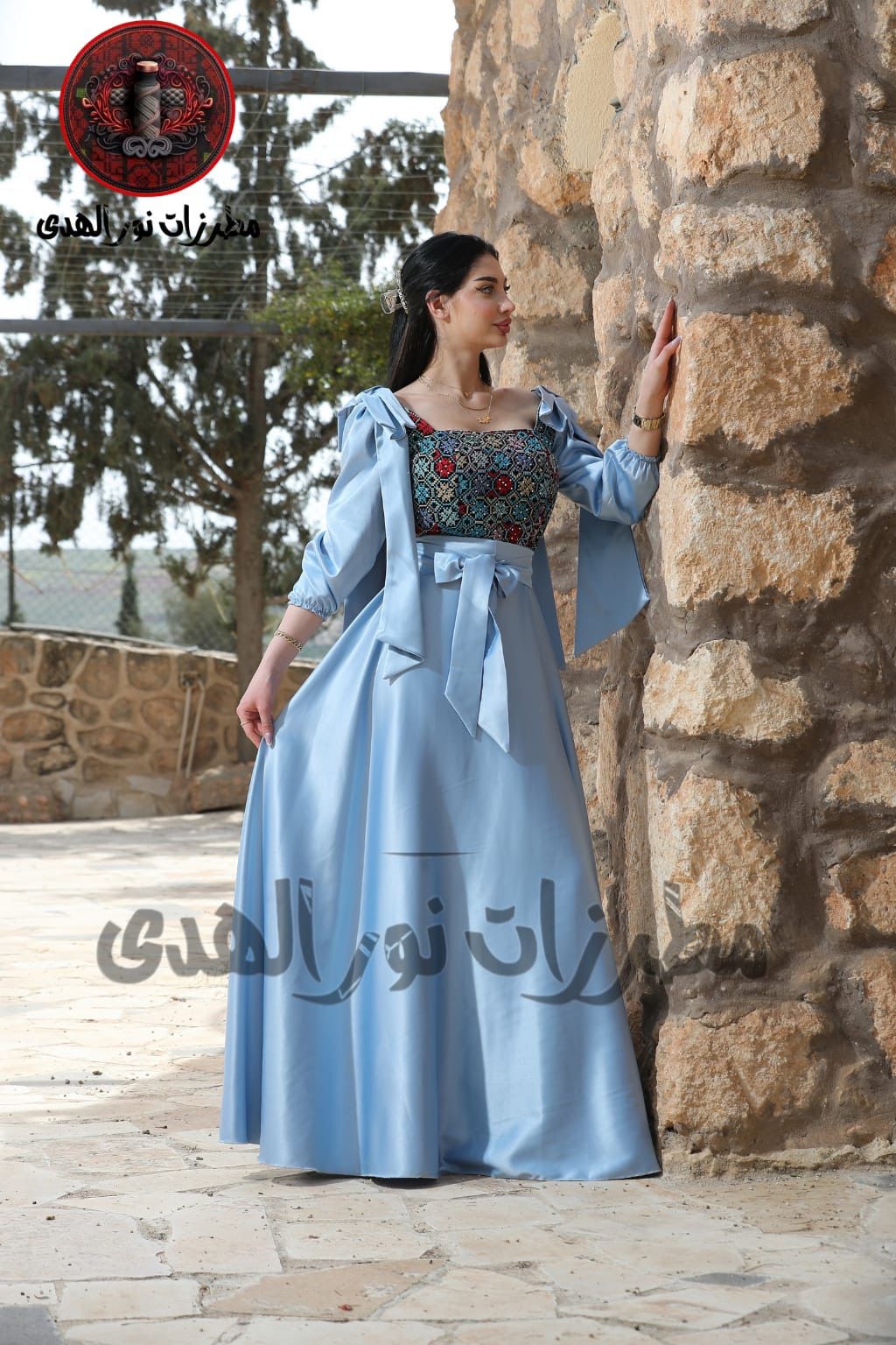 Sky blue long satin Oriental embroidered dress with Tatreez-inspired bodice, waist bow, and matching sleeve styling