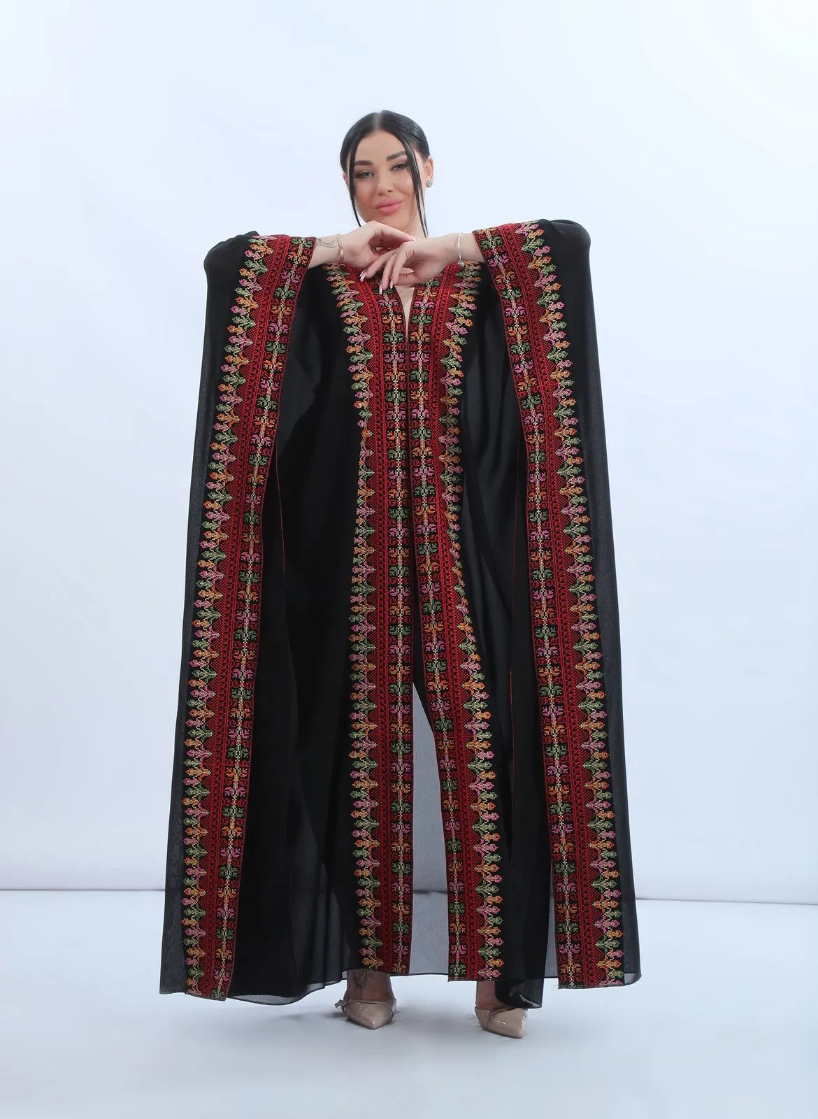 Khaleeji bisht spread wide to reveal four vertical embroidered panels in red, green, pink and apricot on black chiffon, بشت خليجي منشور بالكامل يكشف أربعة أشرطة تطريز عمودية بالأحمر والأخضر والوردي والمشمشي على الشيفون الأسود