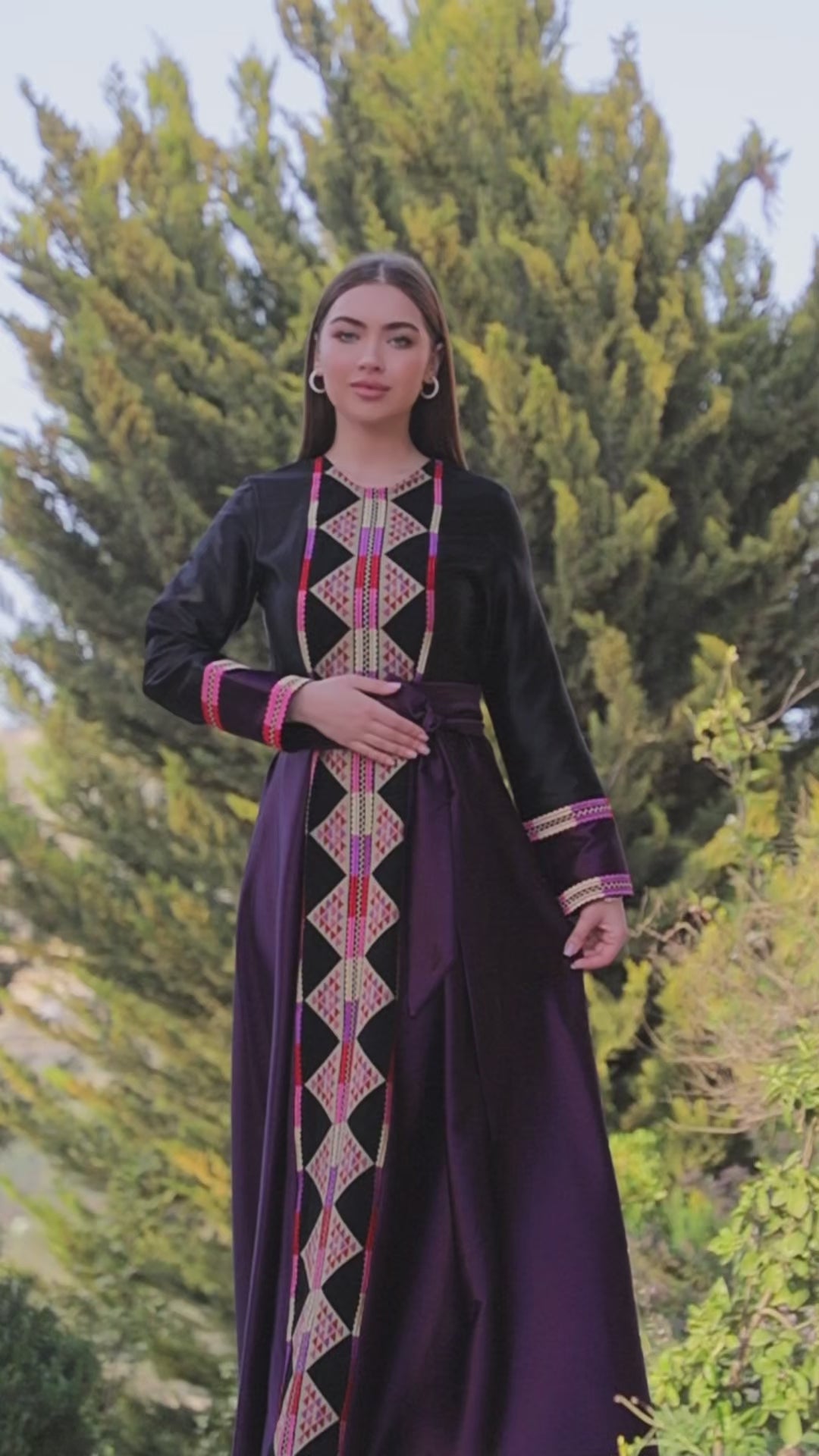 تحميل الفيديو: Black satin Palestinian embroidered thobe with colorful Tatreez-inspired front panel, long sleeves, and black satin belt, ثوب فلسطيني مطرز باللون الأسود من قماش الستان مع تطريز ملون مستوحى من التطريز الفلسطيني وحزام ستان أسود