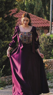 Burgundy long satin Palestinian embroidered heritage dress with fitted Tatreez-inspired bodice and flowing silhouette